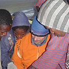 Porters and Pal Tande looking at pictures of the Seven Summits